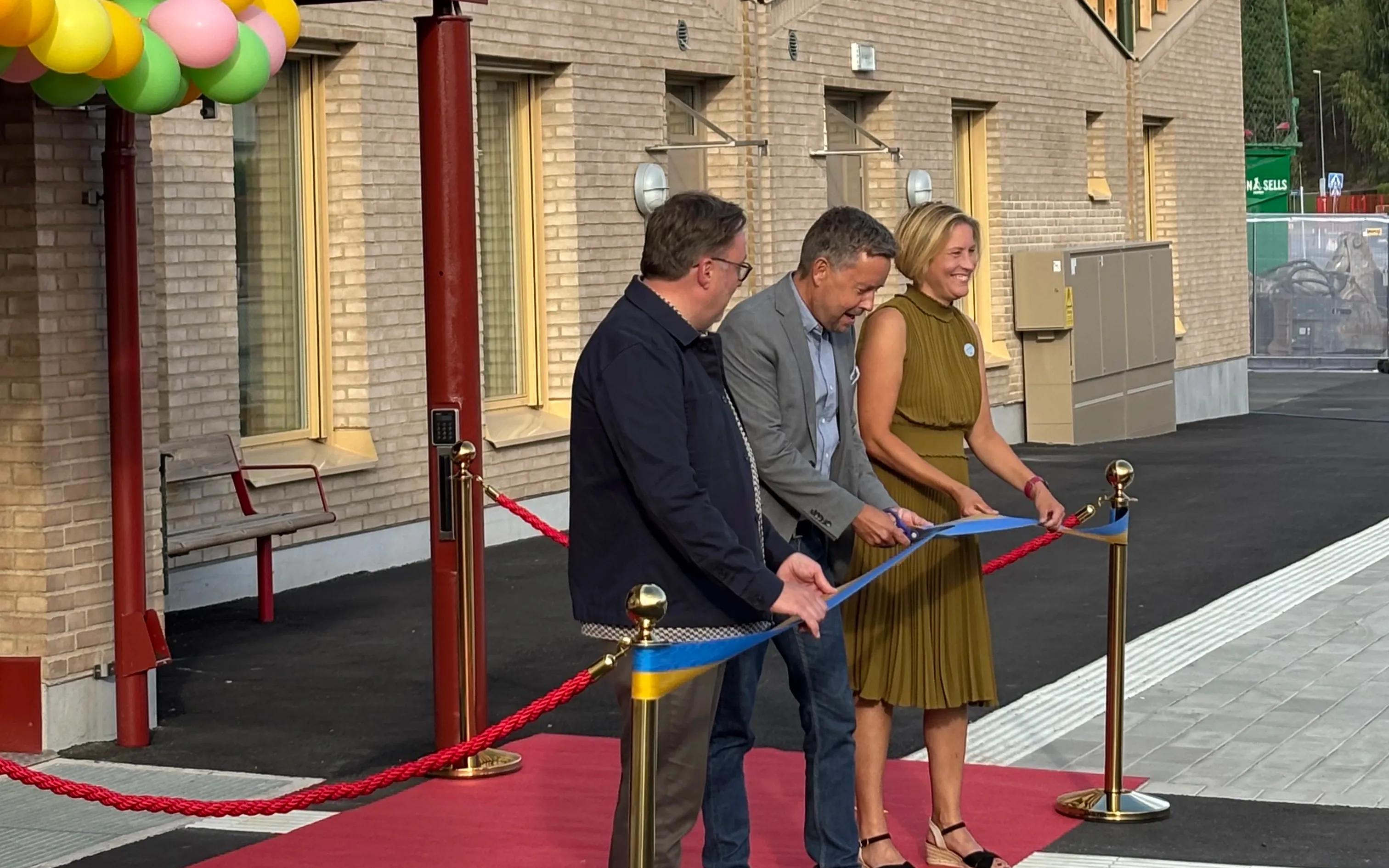 Fredrick Tjus, rektor Sanduddens skola, Sivert Åkerljung (KD), ordförande i barn- och utbildningsnämnden och Hanna Svensson (S), kommunstyrelsens ordförande, klipper band framför huvudentrén till skolan.