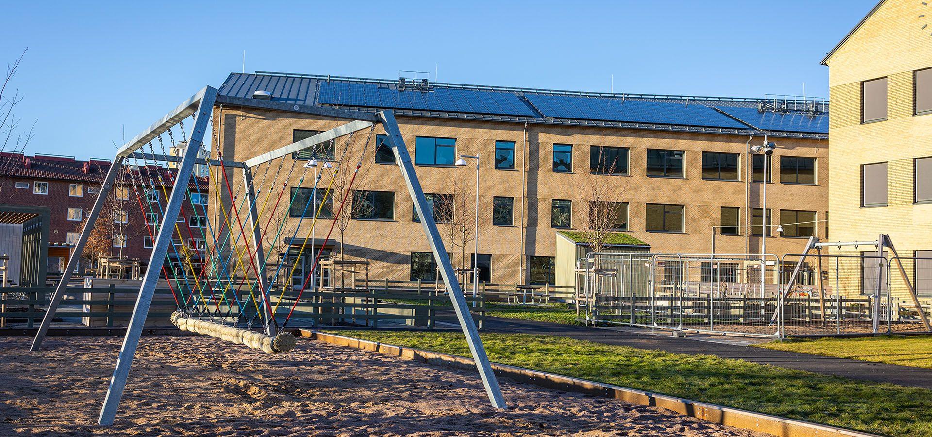 Fasadbild på Skytteskolan med skolgård i förgrunden